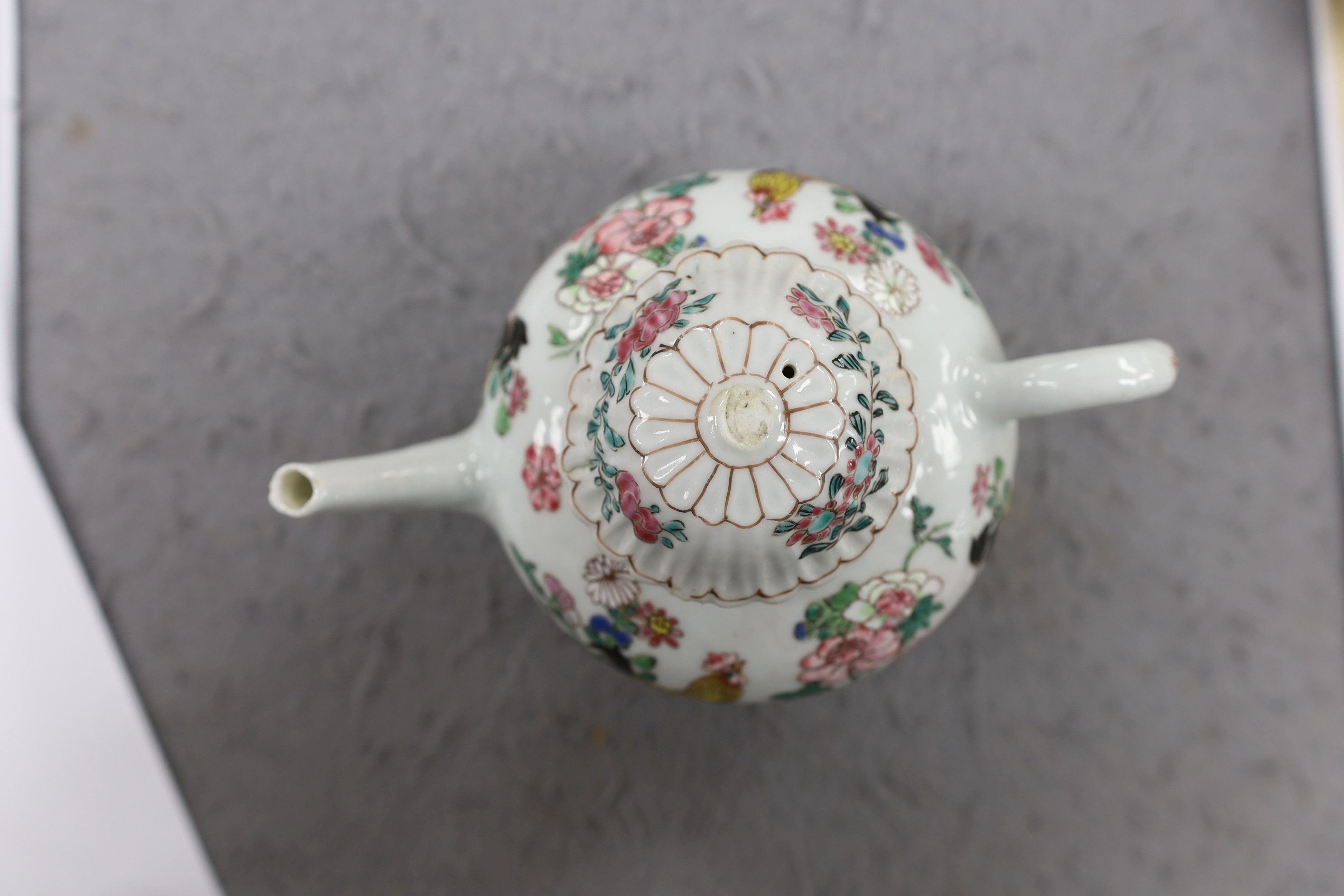 A Chinese famille rose chrysanthemum moulded teapot, early Qianlong period, painted with a cockerel amongst flowers, on a cage work base, 10 cms high
